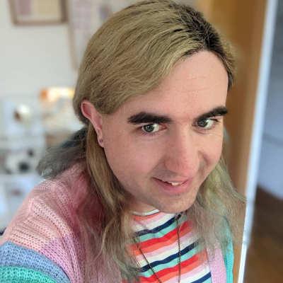 A picture of my head and shoulders wearing a dress, necklace, cardigan and ear studs